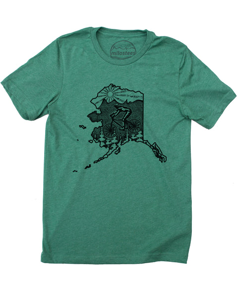 Green Alaska cycling t-shirt featuring a mountain biker and cedar trees. Screen-printed design with mountain logo and setting sun.