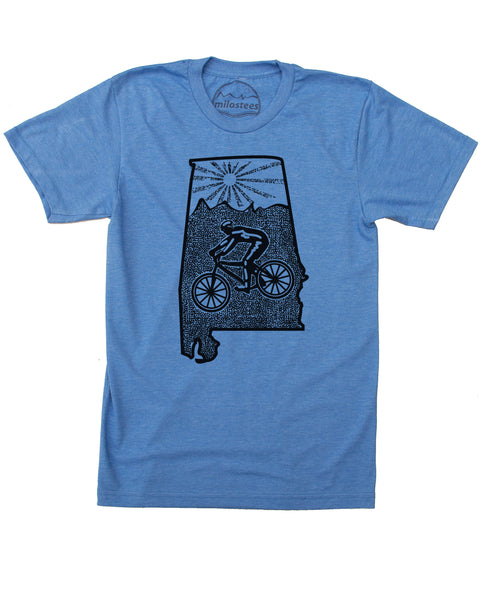 Blue mountain bike Alabama T-shirt with a cyclist riding across the middle of the state, the top portion has our rolling hills logo, above the logo is a setting sun. Black ink 