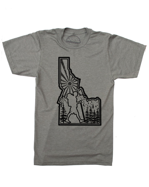Hike Idaho shirt, army green color, original hand screen printed graphic of a hiker hiking inside the State outline of Idaho, infilled with sun mountains and trees. $21.99, free shipping in the USA.