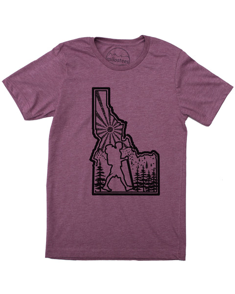 Hike Idaho shirt, plum color, original hand screen printed graphic of a hiker hiking inside the State outline of Idaho, infilled with sun mountains and trees. $21.99, free shipping in the USA. 