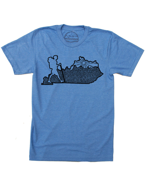 Kentucky home tee, hand screen print of a hiker in KY, complete with rolling hills and setting sun all of which infill the Blue Grass state. Cotton, polyester blend by American Apparel in a blue hue. $21.99, free shipping in USA.