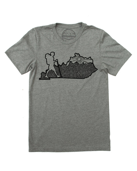 Kentucky home tee, hand screen print of a hiker in KY, complete with rolling hills and setting sun all of which infill the Blue Grass state. Cotton, polyester blend by Bella + Canvas in a grey hue. $21.99, free shipping in USA.