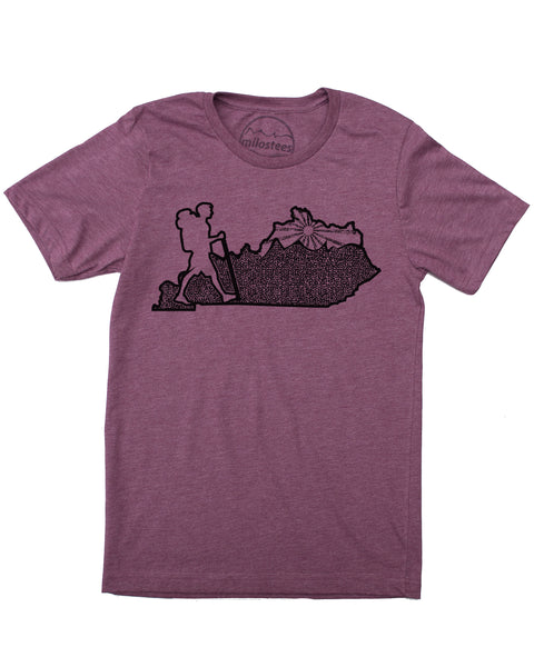 Kentucky home tee, hand screen print of a hiker in KY, complete with rolling hills and setting sun all of which infill the Blue Grass state. Cotton, polyester blend by Bella + Canvas in a plum hue. $21.99, free shipping in USA.