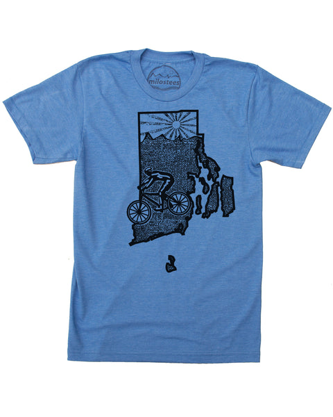 A blue t-shirt with a screen-printed design featuring a cyclist, rolling hills, and a setting sun. All elements are contained within the outline of a state.