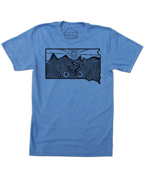  Black screen-printed graphic on a blue t-shirt. Design features a mountain biker rolling across the state.  With a setting sun in the background.